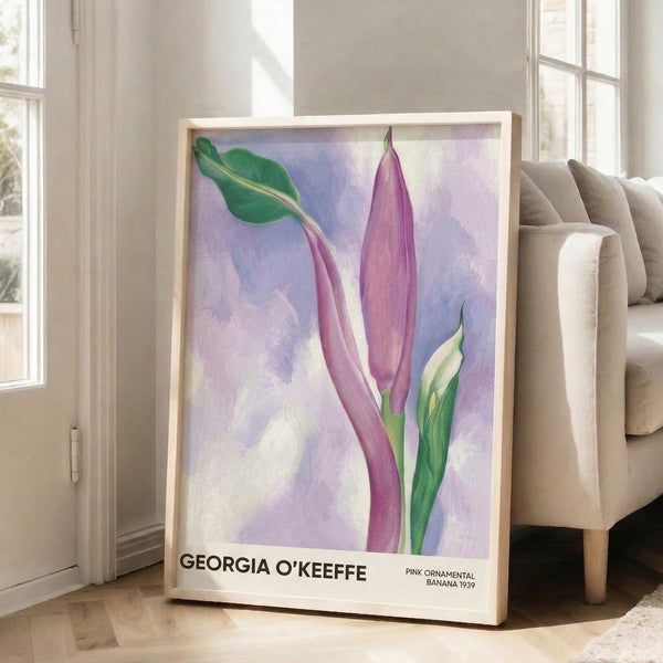 Framed watercolor art showing an intimate close-up of a pink banana flower in soft mauve and rose tones with graceful green leaves, evoking a peaceful botanical mood.