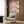 Japandi-style decorative poster merging serene bird motifs with pine branches beneath soft pink clouds in calming palette of blacks, greens, and pale tones.