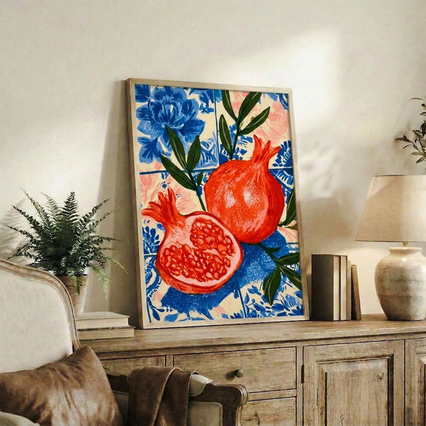 Framed poster displaying a stylized pomegranate composition with pink blossoms and green botanical elements on a cream and blue decorative tile pattern.
