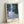 Tranquil pond artwork with blooming water lilies rendered in soft blue and cream hues, evoking a peaceful impressionist garden setting.