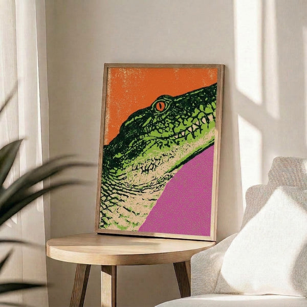 Contemporary pop art reptile print featuring a striking iguana rendered in bright neon green, orange, and hot pink hues with black accents, displayed as a framed wall poster.