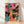 Pop art framed poster of three energetic musicians with drum and guitar in hot pink, teal, orange, and yellow abstract brushstrokes on a black background.