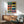 Colorful pop art grid composition of an iconic Leica camera in teal, yellow, purple, and coral hues, printed as a retro-style poster and hung framed on wall.