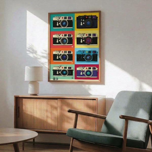 Colorful pop art grid composition of an iconic Leica camera in teal, yellow, purple, and coral hues, printed as a retro-style poster and hung framed on wall.