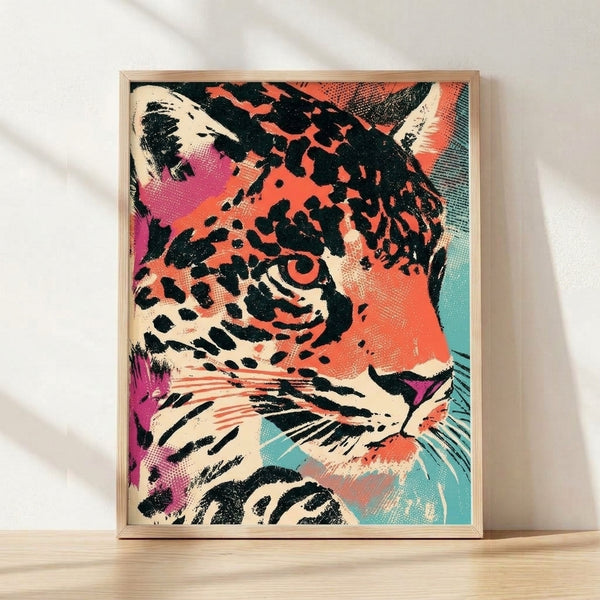 Bold pop art leopard portrait with a vibrant face in coral, magenta, and teal against a cream background, framed on a wall as modern retro wall art.