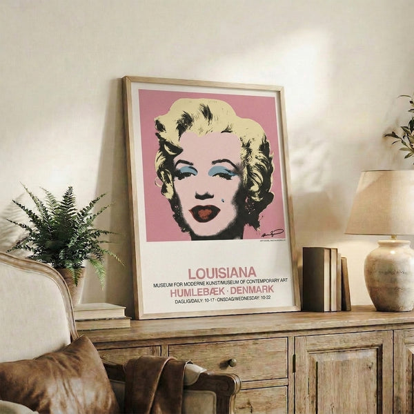 Framed pop art poster featuring a woman's portrait in striking pink, black, and blue—a bold, glamorous take on modern iconic imagery.