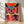 Bold pop art owl portrait with bright red, coral, and navy blue tones accented by gold details, displayed as a framed poster on a wall.