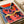 Energetic abstract owl wall print in bold pop art style with bright coral and red tones, navy blue, and gold detailing on dark background.