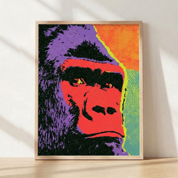 Bold pop art gorilla portrait with vibrant red, purple, yellow, and green tones on black background, framed as a poster on a wall.