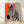 Bold pop art zebra portrait in vibrant orange, pink, and teal with black stripes and cream accents, displayed as a framed poster on a wall.
