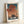 Adventurous wall art featuring a vintage-style aircraft soaring over misty waters and a distant fortress under a burnt sienna and cream night sky.