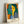 Minimalist portrait artwork with simplified facial features in yellow, green, and blue, conveying an introspective and elegant aesthetic on a white background.