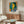 Framed poetic portrait of a woman rendered with abstract forms and a striking palette of yellow, blue, and green suggesting quiet introspection.