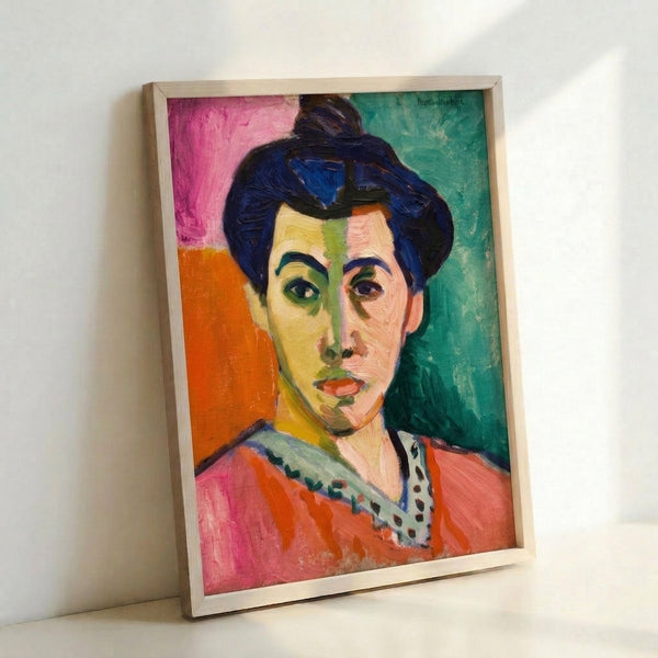 Framed abstract portrait print showing a stylized female face with an iconic green stripe, blending soft watercolor technique with vibrant color blocking in warm and cool hues.