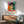 Modern portrait print of a woman with gestural, expressive marks in green, red, and ochre creating an intimate yet abstract composition.
