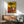 Faceless surreal portrait featuring bold abstract shapes and forms in vivid primary colors mixed with earth-toned accents on framed wall art.