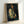 Framed art print displaying a dignified portrait in Cezanne's distinctive style, using layered brushwork and a restrained color palette of browns and blues.
