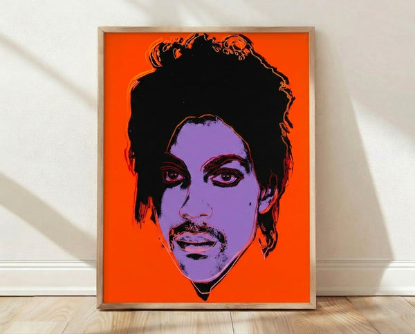 Pop art portrait of Prince in vibrant neon colors with bold graphic style, framed poster art print displayed on a wall.