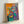 Matisse-inspired wall art print showing a figure draped in purple with dynamic, curving forms and blooming anemone flowers in rich jewel tones.