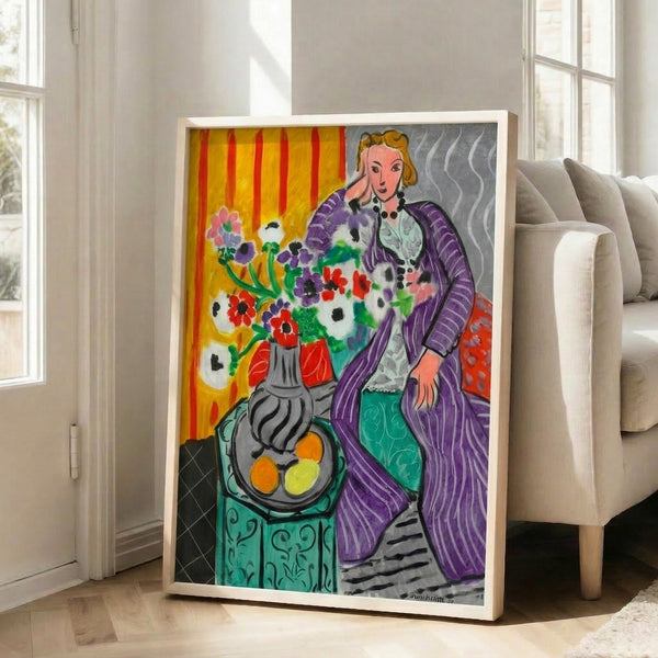 Vibrant framed poster of a reclining figure in purple robes surrounded by freely painted anemones, reflecting bold modernist style and warm color harmony.