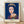 Pop art portrait of Queen Elizabeth II in dark blue and white tones, framed on a wall as a modern minimalist print with iconic regal appeal.