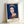 Dark blue and white pop art interpretation of a regal portrait, displayed as a framed modern art print with bold, simplified forms.