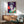 Pop art interpretation of Queen Elizabeth II rendered in purple hues, displayed as a contemporary art print on a wall.