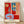 Bold modern abstract still life featuring a red interior with a blue table, vibrant geometric forms in red, green, and white on a framed poster.