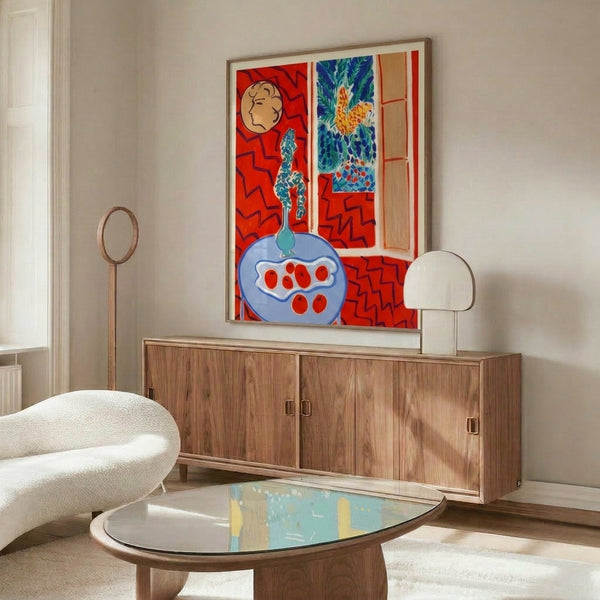 Expressively bold framed artwork featuring an abstract still life interior in reds and blues with geometric green and white accents.