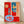 Abstract still life composition with bold red and blue tones, featuring geometric forms and simplified objects arranged on a table in modernist style.