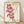 Framed Japanese woodblock print featuring red and cream koi fish swimming gracefully among green bamboo leaves and plant stems in folk art style.