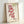 Auspicious Japanese wall art depicting elegant koi fish in red tones with black ink details, surrounded by bamboo and botanical elements in folk art style.