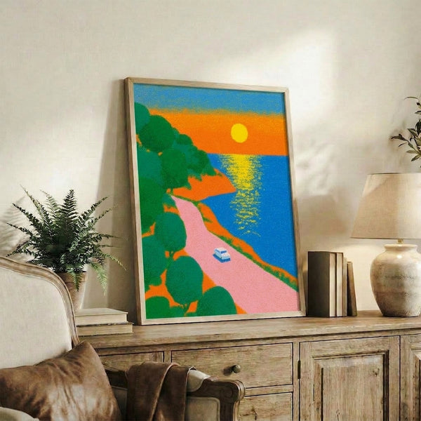 Vibrant retro-style framed art print of a classic car on a seaside highway at golden hour, rendered in bold pinks, oranges, blues, and yellows with a modern pop art aesthetic.