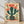 Retro boho poster of blooming cacti and succulents in a desert garden, with coral red flowers and sage green plants against a cream background, framed on a wall.