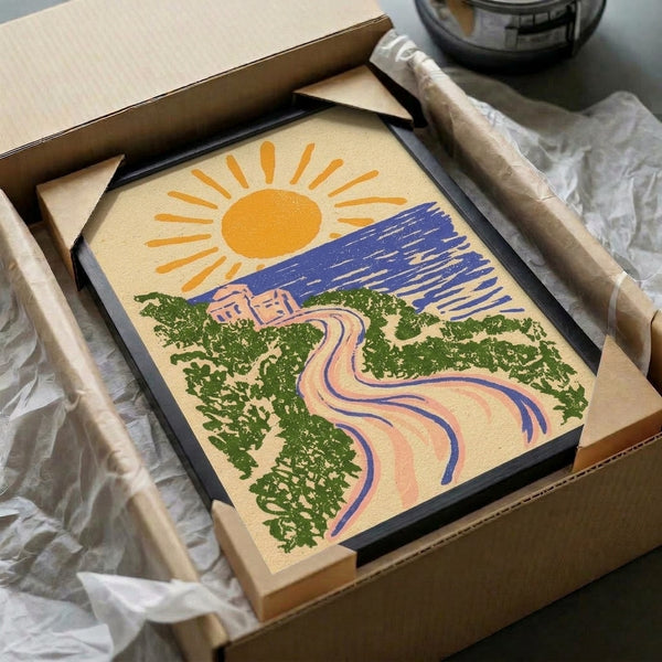 Vintage-inspired framed print of a golden sun setting over a tranquil ocean landscape with cream pathway, navy waters, green trees, and coral building details in a calming, retro minimalist style.