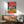 Playful folk art poster of crocodiles enjoying a celebratory feast with party hats, wine glasses, and tropical elements in a retro boho style palette of hot pink, forest green, and coral orange.
