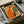 Quirky framed poster of a fox enjoying a warm beverage, styled as retro folk art in bright orange, forest green, and cream with a whimsical, cozy mood.