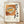 Retro Japanese woodblock-style poster featuring a steaming bowl of katsu ramen with noodles, broth, and chopsticks in warm tan, orange, and cream tones with black accents.