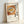 Framed poster art showing an appetizing ramen bowl composition in woodblock print style with warm cream and orange hues, capturing the essence of Fukuoka's ramen culture.
