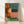 Retro 1970s motel room scene with a solitary figure in bed beside a glowing nightstand lamp, warm orange and teal color palette, framed poster art on wall.