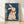 Whimsical folk art poster featuring a rabbit playing violin with an arrow motif, rendered in deep teal, cream, coral, navy, and ochre tones in a retro style.
