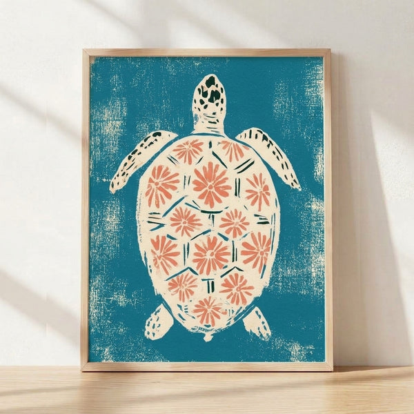Framed linocut art print featuring a sea turtle surrounded by delicate coastal flowers in teal, cream, coral, and navy tones, displayed on a wall.