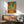 Minimalist sunrise artwork with concentric sunburst design in warm burnt orange and mustard hues, evoking uplifting retro-modern bedroom wall decor.