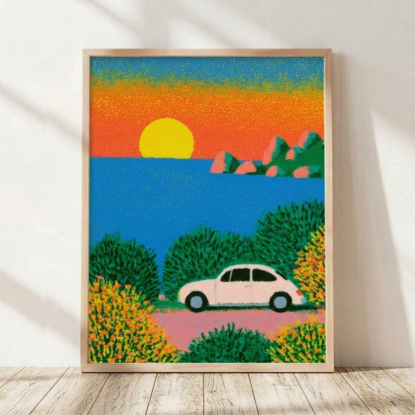 Framed retro poster art featuring a vintage Beetle car on a coastal road at sunset, rendered in bright yellows, oranges, and electric blues with minimalist landscape elements including water, rocks, and flowers in forest green and coral tones.
