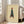 Wabi sabi wall art depicting a gracefully walking woman in a teal coat, rendered as a minimalist line drawing in cream and earthy tones, framed as a sophisticated poster.