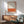 Minimalist framed art featuring cream, burnt orange, and red abstract color fields arranged horizontally, evoking contemplative mood.