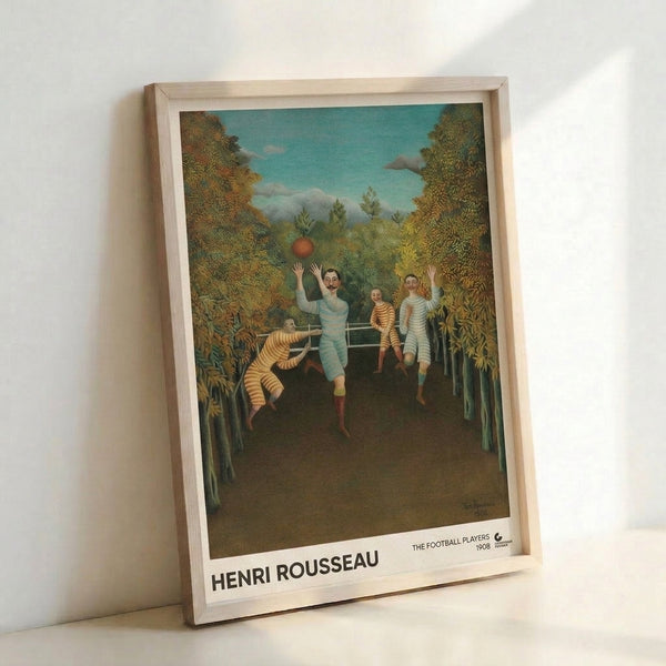 Framed print of The Football Players by Henri Rousseau, showcasing figures at play in a dreamlike woodland setting with cream, teal, and ochre palette in his distinctive folk art style.
