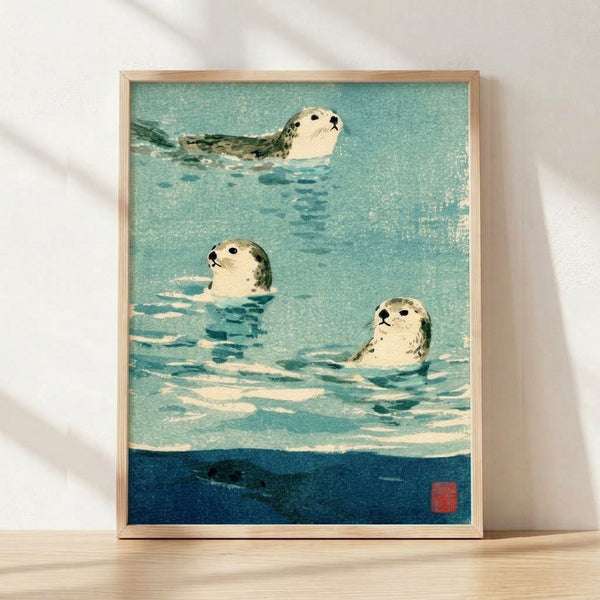 Framed watercolor poster of three seals swimming in turquoise and dark blue water with sage green accents, rendered in a serene Japanese woodblock minimalist style.