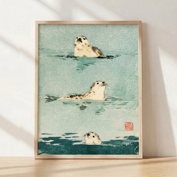 Framed watercolor poster of three seals in seafoam green and teal tones, rendered in minimalist Japanese style with serene ocean setting.