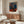 Modern poster art featuring an expressionistic seated figure surrounded by geometric forms in ochre and grey, creating an atmosphere of psychological intensity.